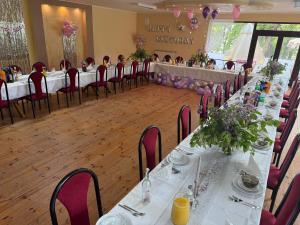a banquet hall with white tables and chairs and flowers at Zajazd Rybaki in Płock