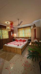 a bedroom with a large bed with red flowers on the floor at African Treasure Beach Resort in Kokrobite