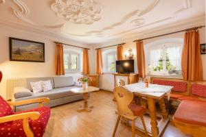 a living room with a couch and a table at Schwabenbauernhof-Tradition und Moderne erleben in Ruhpolding