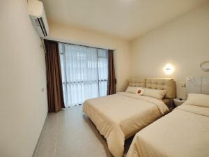 Una habitación de hotel con dos camas y una ventana. en Yangshuo Chechen, en Yangshuo 7 fotos más