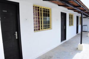 a white building with black doors and yellow windows at RDS Guest House Bypass in Āmbūr