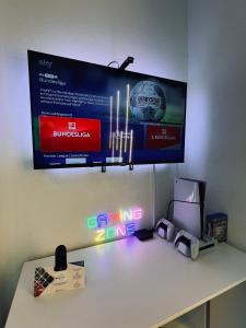 ein Fernseher, der mit Neonlichtern an einer Wand hängt in der Unterkunft Comfort & Relax mit Sky & PlayStation - Haus Burgstadt in Altena