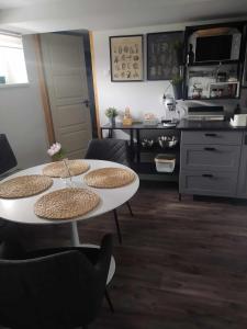a kitchen with a table with four chairs and a counter at Home Apartman in Nagyesztergár