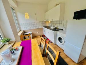 eine Küche mit einem Tisch und einer Waschmaschine in der Unterkunft Comfort & Relax mit Sky & PlayStation - Haus Burgstadt in Altena