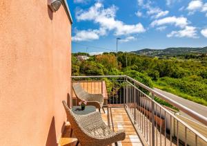 a balcony with two chairs and a table at Villa Elegance - With Garden and Private Gym in Livorno