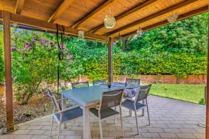a patio with a table and chairs under a wooden pergola at Villa Elegance - With Garden and Private Gym in Livorno