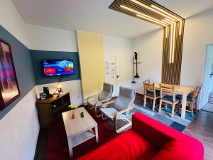 ein Wohnzimmer mit einem roten Sofa und einem Tisch in der Unterkunft Comfort & Relax mit Sky & PlayStation - Haus Burgstadt in Altena