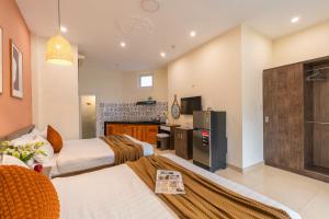een hotelkamer met twee bedden en een keuken bij Green Meadow Central Đà Lạt - O'TEL in Da Lat