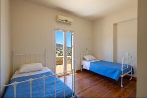 PosidhoníaにあるVilla Maria Syrosの窓のある部屋にベッドが2つある