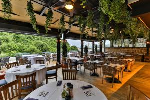 a restaurant with white tables and chairs and plants at Regent Resort Budva in Budva
