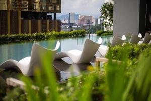 a row of white chairs sitting next to some water at Luxury Suites At The Mews KLCC in Kuala Lumpur