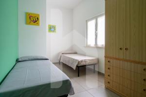 a bedroom with a bed and a bench and a window at Homiday - Appartamento Rosy in Pineto +5 photos
