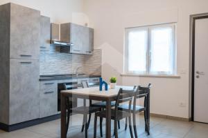 a kitchen with a table and chairs in a room at Homiday - Appartamento Rosy in Pineto