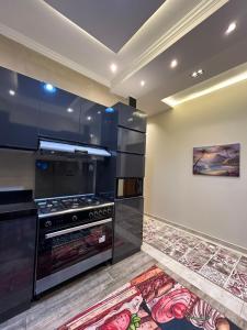 开罗Modern 3-BR in New Cairo Lotus的厨房配有炉灶,墙上挂有绘画作品