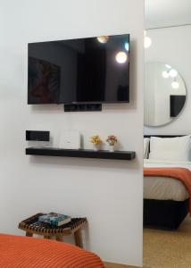 a room with a tv on a wall with a bed at Dema Luxury Suites - Romvis in Athens