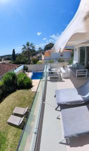 eine Terrasse mit Liegestühlen und ein Swimmingpool in der Unterkunft Villa Serena Marbella-Elviria in Marbella