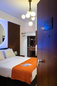 a bedroom with a bed with an orange blanket at Dema Luxury Suites - Romvis in Athens +32 photos