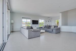 ein weißes Wohnzimmer mit zwei Sofas und einem Fernseher in der Unterkunft Villa Serena Marbella-Elviria in Marbella