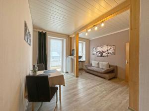 a living room with a table and a couch at Gast und Weinhof Beim Schneemann in Valwig