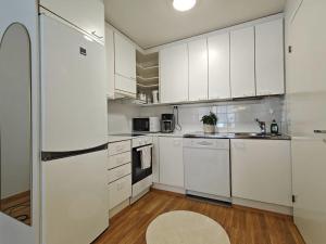a white kitchen with white cabinets and appliances at 46m2 - Location - Parking space - Sauna - Self check-in in Jyväskylä +22 photos