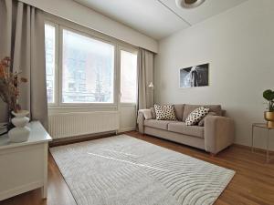 a living room with a couch and a large window at 46m2 - Location - Parking space - Sauna - Self check-in in Jyväskylä
