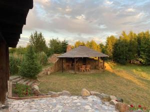 a gazebo with a table and chairs in a yard at Domek Stojkowo in Stojkowo +5 photos