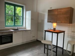 eine Küche mit weißen Schränken und einem Tisch mit einer Lampe darauf in der Unterkunft Große Wohnung Oberntor in Stadthagen