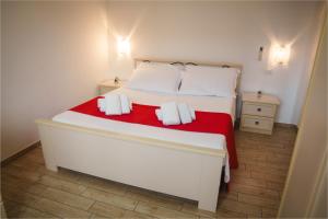 a bedroom with a large white bed with red blanket at Villa Giusi in Tropea