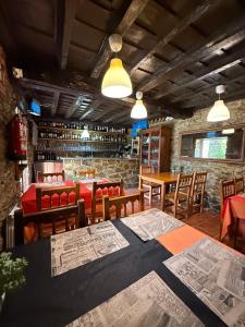 a restaurant with tables and chairs with maps on the tables at La Casona de Faedo Pensión in Faedo