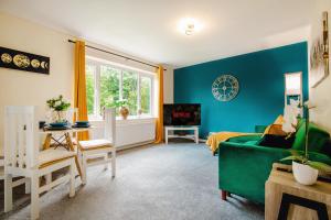 un salon avec des murs bleus et un canapé vert dans l'établissement Central Blue Haven Retreat Free Parking 8ppl!, à Victoria