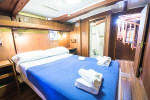 een slaapkamer met een blauw bed met handdoeken erop bij Nave Contessa in Rimini