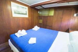 een slaapkamer met een blauw bed in een boot bij Nave Contessa in Rimini +47 foto's