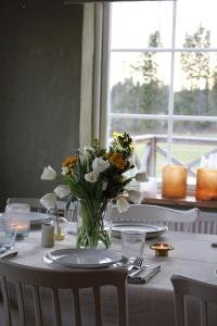 a table with a vase of flowers on a table at Allsta Gård in Bjärtrå