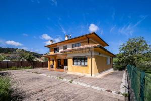 una casa amarilla con una valla delante en Casina de Arroes By Silastur, en Arroes