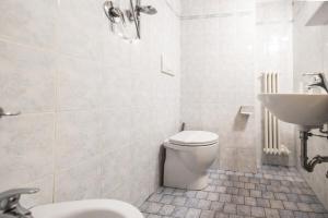 a white bathroom with a toilet and a sink at Family Nest - Tra il Mare, il Centro e il Relax in Misano Adriatico
