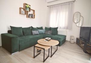 a living room with a green couch and a table at Swans Luxury Apt in Kastoria +17 photos