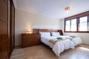 1 dormitorio con 2 camas, vestidor y ventana en Casina de Arroes By Silastur, en Arroes