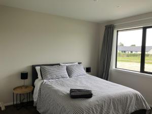 a bedroom with a bed with a black bag on it at 3-Bedroom Retreat in Mount Somers in Mount Somers