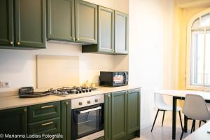 a kitchen with green cabinets and a table at 8 Archi sul Mare Exclusive Ferris Wheel View in Bari