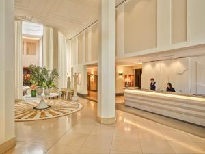 a lobby of a building with people in it at Rocco Forte The Charles Hotel in Munich