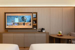 a television sitting on a cabinet in a room at 西安明城墙永兴坊桔子水晶酒店 in Xi'an