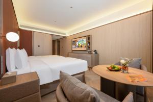 a hotel room with a bed and a table and chairs at 西安明城墙永兴坊桔子水晶酒店 in Xi'an