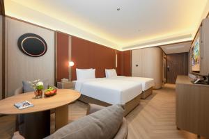 a hotel room with a large bed and a table at 西安明城墙永兴坊桔子水晶酒店 in Xi'an