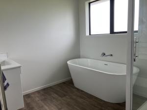 a white bathroom with a tub and a window at 3-Bedroom Retreat in Mount Somers in Mount Somers