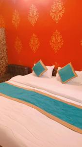 2 camas individuales en una habitación con una pared de color naranja en Hotel SwasthiK Residency, en Dehradun
