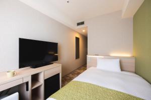 a hotel room with a bed and a flat screen tv at Shinjuku Washington Hotel Annex in Tokyo