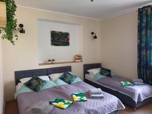 a bedroom with two beds and a painting on the wall at Dom JAMAR - apartamenty in Jastrzębia Góra