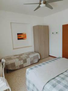 a bedroom with two beds and a ceiling fan at Locanda Zona Franca in San Benedetto del Tronto +13 photos