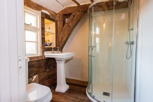 ein Badezimmer mit Waschbecken und Glasdusche in der Unterkunft Taper House - Cosy Medieval Cottage in Kersey + 22 Fotos