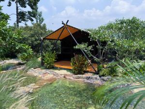 a gazebo in the middle of a garden at Green Love Garden Resort in Ban Bung Mai